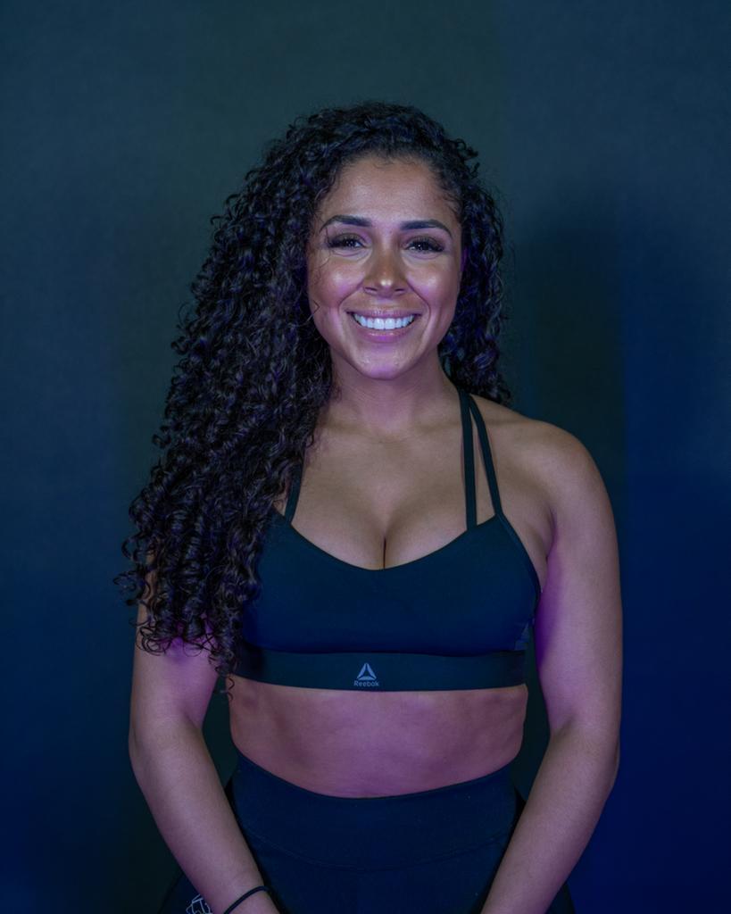 Lady smiling with a navy blue wall behind her